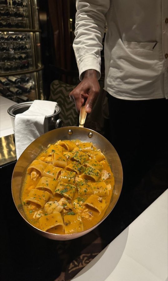 A waiter carrying a pan of pasta