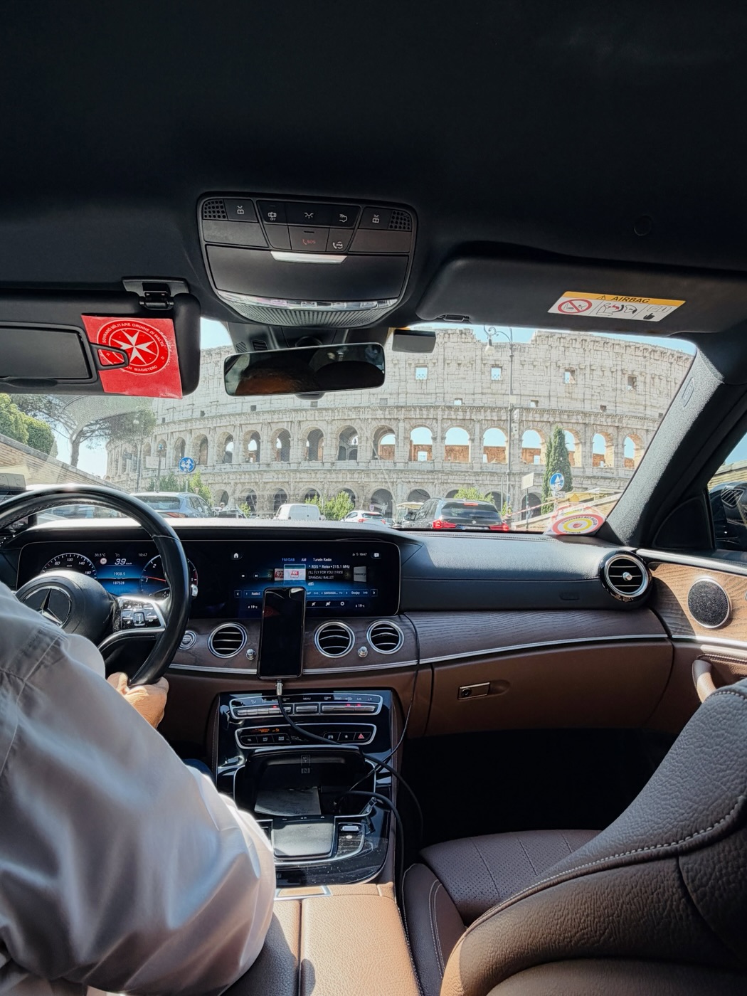 The Colosseum through the windscreen of a private car